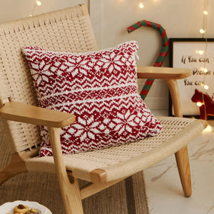 A festive cushion cover featuring a woven texture and snowflake motifs inspired by Fair Isle patterns. 