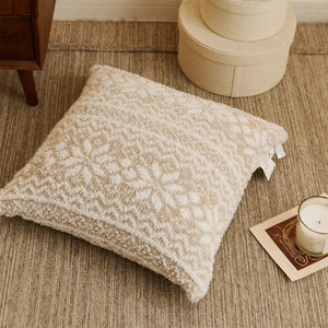 A festive cushion cover featuring a woven texture and snowflake motifs inspired by Fair Isle patterns. 