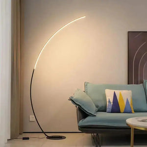 A modern Kumo Floor Lamp featuring a sleek, arched design with an aluminum shade. The lamp emits warm LED light.