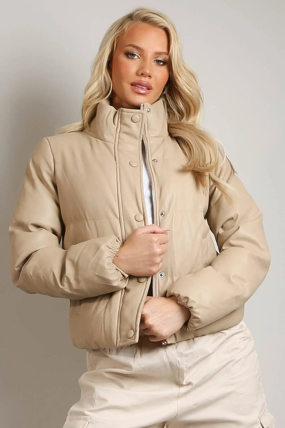  A high neck design for added warmth, side pockets for convenience, and a front button closure for a sleek, modern look. 